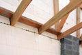 The wooden structure of the building. Installation of wooden beams at construction the roof truss system of the house.