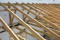 The wooden structure of the building. Wooden frame building. Wooden roof construction. Installation of wooden beams