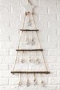 Wooden stylish Christmas tree in scandinavian style against the background a white brick wall