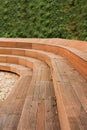 Wooden stylish modern city benches against green grassy wall, vertical, selective focus Royalty Free Stock Photo