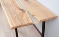 Wooden stylish table made of solid wood with epoxy resin on the background of the floor and wall. Close-up