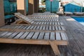 Wooden sun loungers near the houses by the pool