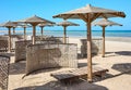 Wooden sun umbrellas, sun beds and windscreens on beach