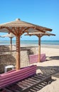 Wooden sun umbrellas, sun beds and windscreens on beach