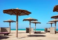 Wooden sun umbrellas, sunbed and windscreens on beach, Marsa Alam, Egypt