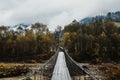 Wooden suspension bridge over a mountain river in a mountain village 1 Royalty Free Stock Photo