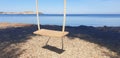 Wooden swing against the background of the sea and the city of Portoferraio.