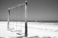 Wooden swing on the beach, monochrome. Swing with two seats on scenic seascape, black and white. Idyllic exotic resort.