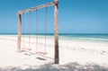 Wooden swing on the beach. Swing with two seats on scenic seascape. Idyllic exotic resort. Tropical paradise. Empty swing.
