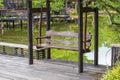 Wooden swing bench in tropical garden near pond, Thailand Royalty Free Stock Photo