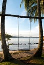 Wooden swing chair hanging on tree near beach at island in Phuket, Thailand. Summer Vacation Travel and Holiday concept. Royalty Free Stock Photo