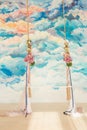 Wooden swing decorated with bouquets of flowers