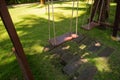 Wooden swing hanging in a beautiful garden near the bungalow. The inner territory of a beautiful hotel on the seafront