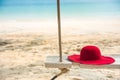 Wooden swing with a hat on tropical beach for summer and vacation.