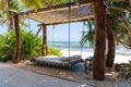 Wooden swing with a mattress and pillows under a canopy on the tropical beach near sea, island Zanzibar, Tanzania, East Africa Royalty Free Stock Photo