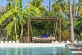 Wooden swing with a mattress under a canopy on the tropical beach near swimming pool, island Zanzibar, Tanzania, East Africa Royalty Free Stock Photo