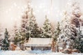 Wooden swing in a snow-covered park or forest with spruce trees and stumps, big candles in glass vases, while snowing Royalty Free Stock Photo