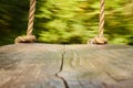 wooden swing with thick ropes. the camera is standing on a swing, blurred background is a park, a wooden swing Royalty Free Stock Photo