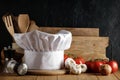 Wooden table background with dark wall and kitchen utensils and vegetables.