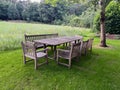 Wooden table with bench and chairs in garden. Landscape design Royalty Free Stock Photo