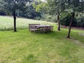 Wooden table with bench and chairs in garden. Landscape design Royalty Free Stock Photo