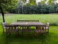 Wooden table with bench and chairs in garden. Landscape design Royalty Free Stock Photo