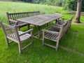 Wooden table with bench and chairs in garden. Landscape design Royalty Free Stock Photo