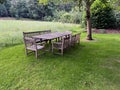 Wooden table with bench and chairs in garden. Landscape design Royalty Free Stock Photo