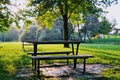 Wooden table and bench inside the park on the red pattern and sun shine after trees. Royalty Free Stock Photo