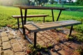 Wooden table and bench inside the park on the red pattern and sun shine after trees. Royalty Free Stock Photo