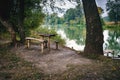 A wooden table and a bench on the river bank Royalty Free Stock Photo