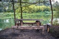 A wooden table and a bench on the river bank. A beautiful place Royalty Free Stock Photo