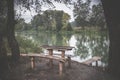 A wooden table and a bench on the river bank. A beautiful place Royalty Free Stock Photo