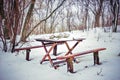 Wooden table and bench in the woods under the snow Royalty Free Stock Photo