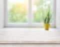 Wooden table on blurred autumn window with plant pot background