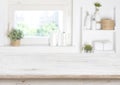 Wooden table on blurred background of bathroom window and shelves