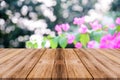 wooden table on blurred bokeh background with pink flowers in the park Concept for cutting product presentation and design Royalty Free Stock Photo