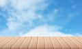 Wooden table with blurred blue sea of blue sky with clouds on background - For product display.