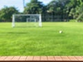 Wooden table with blurred of small soccer field for background.