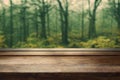 a wooden table with a blurry background of trees in the woods in the background is a wood floor Royalty Free Stock Photo