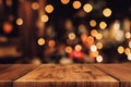 a wooden table with blurry lights in the background of a room with a wooden table top and a wooden floor Royalty Free Stock Photo