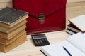 On a wooden table books, documents, calculator, red briefcase. Royalty Free Stock Photo