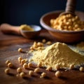 Wooden table with bowl of yellowish-orange powder on it. This powder is likely to be some kind of spice or seasoning