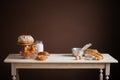 Wooden table on a brown background with baked goods, bread, buns