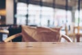 Wooden table and chair with pillow in cafe with blur abstract background Royalty Free Stock Photo