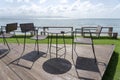 Wooden table and chairs in empty beach cafe next to sea water. Island Koh Phangan, Thailand Royalty Free Stock Photo