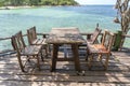 Wooden table and chairs in empty beach cafe next to sea water. Island Koh Phangan, Thailand Royalty Free Stock Photo