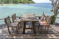 Wooden table and chairs in empty beach cafe next to sea water. Island Koh Phangan, Thailand Royalty Free Stock Photo