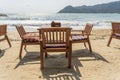 Wooden table and chairs in empty beach cafe next to sea water. Close up, Thailand Royalty Free Stock Photo