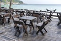 Wooden table and chairs in empty beach cafe next to sea water. Island Koh Phangan, Thailand Royalty Free Stock Photo